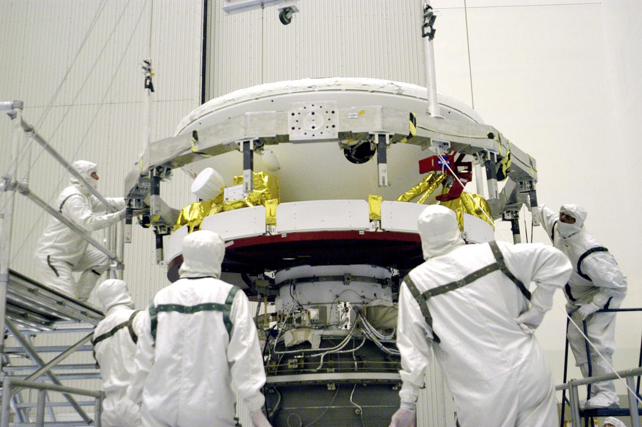 KENNEDY SPACE CENTER, FLA. -In the Payload Hazardous Servicing Facility, workers prepare to mate the Mars Exploration Rover 1 (MER-B) above with the third stage of the Delta rocket below.  The second of twin rovers being sent to Mars, it is equipped with a robotic arm, a drilling tool, three spectrometers, and four pairs of cameras that allow it to have a human-like, 3D view of the terrain. Each rover could travel as far as 100 meters in one day to act as Mars scientists' eyes and hands, exploring an environment where humans can't yet go.  MER-B is scheduled to launch from Launch Pad 17-B, Cape Canaveral Air Force Station, June 26 at one of two available times,  12:27:31 a.m. EDT or 1:08:45 a.m. EDT.