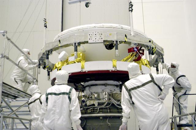 NASA image: KENNEDY SPACE CENTER, FLA. -In the Payload Hazardous Servicing Facility, workers prepare to mate the Mars Exploration Rover 1 (MER-B) above with the third stage of the Delta rocket below.  The second of twin rovers being sent to Mars, it is equipped with a robotic arm, a drilling tool, three spectrometers, and four pairs of cameras that allow it to have a human-like, 3D view of the terrain. Each rover could travel as far as 100 meters in one day to act as Mars scientists' eyes and hands, exploring an environment where humans can't yet go.  MER-B is scheduled to launch from Launch Pad 17-B, Cape Canaveral Air Force Station, June 26 at one of two available times,  12:27:31 a.m. EDT or 1:08:45 a.m. EDT.