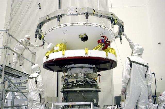 NASA image: KENNEDY SPACE CENTER, FLA. -  In the Payload Hazardous Servicing Facility, workers check the connections after the Mars Exploration Rover 1 (MER-B) above was mated with the third stage of the Delta rocket below.  The second of twin rovers being sent to Mars, it is equipped with a robotic arm, a drilling tool, three spectrometers, and four pairs of cameras that allow it to have a human-like, 3D view of the terrain. Each rover could travel as far as 100 meters in one day to act as Mars scientists' eyes and hands, exploring an environment where humans can't yet go.  MER-B is scheduled to launch from Launch Pad 17-B, Cape Canaveral Air Force Station, June 26 at one of two available times,  12:27:31 a.m. EDT or 1:08:45 a.m. EDT.