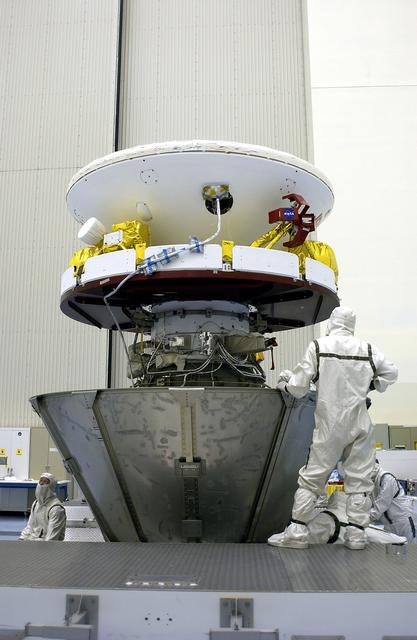 NASA image: KENNEDY SPACE CENTER, FLA. - Workers in the Payload Hazardous Servicing Facility secure the lower panels of a payload canister around Mars Exploration Rover 1 (MER-B).  The rover will be transported to Launch Complex 17-B, Cape Canaveral Air Force Station, for mating with the Delta rocket.  The second of twin rovers being sent to Mars, it is equipped with a robotic arm, a drilling tool, three spectrometers, and four pairs of cameras that allow it to have a human-like, 3D view of the terrain. Each rover could travel as far as 100 meters in one day to act as Mars scientists' eyes and hands, exploring an environment where humans can't yet go.  MER-B is scheduled to launch from Pad 17-B June 26 at one of two available times,  12:27:31 a.m. EDT or 1:08:45 a.m. EDT.