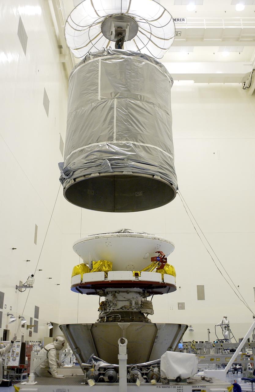 An overhead crane lowers the cylindrical payload canister toward Mars Exploration Rover 1 (MER-B). Once secure inside the canister, the rover will be transported to Launch Complex 17-B, Cape Canaveral Air Force Station, for mating with the Delta rocket. The second of twin rovers being sent to Mars, it is equipped with a robotic arm, a drilling tool, three spectrometers, and four pairs of cameras that allow it to have a human-like, 3D view of the terrain. Each rover could travel as far as 100 meters in one day to act as Mars scientists' eyes and hands, exploring an environment where humans can't yet go. MER-B is scheduled to launch from Pad 17-B June 26 at one of two available times, 12:27:31 a.m. EDT or 1:08:45 a.m. EDT.