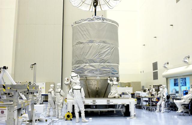 NASA image: KENNEDY SPACE CENTER, FLA. - In the Payload Hazardous Servicing Facility, workers secure the cylindrical payload canister to the lower panels surrounding Mars Exploration Rover 1 (MER-B).  Once secure inside the canister, the rover will be transported to Launch Complex 17-B, Cape Canaveral Air Force Station, for mating with the Delta rocket.  The second of twin rovers being sent to Mars, it is equipped with a robotic arm, a drilling tool, three spectrometers, and four pairs of cameras that allow it to have a human-like, 3D view of the terrain. Each rover could travel as far as 100 meters in one day to act as Mars scientists' eyes and hands, exploring an environment where humans can't yet go.  MER-B is scheduled to launch from Pad 17-B June 26 at one of two available times,  12:27:31 a.m. EDT or 1:08:45 a.m. EDT.