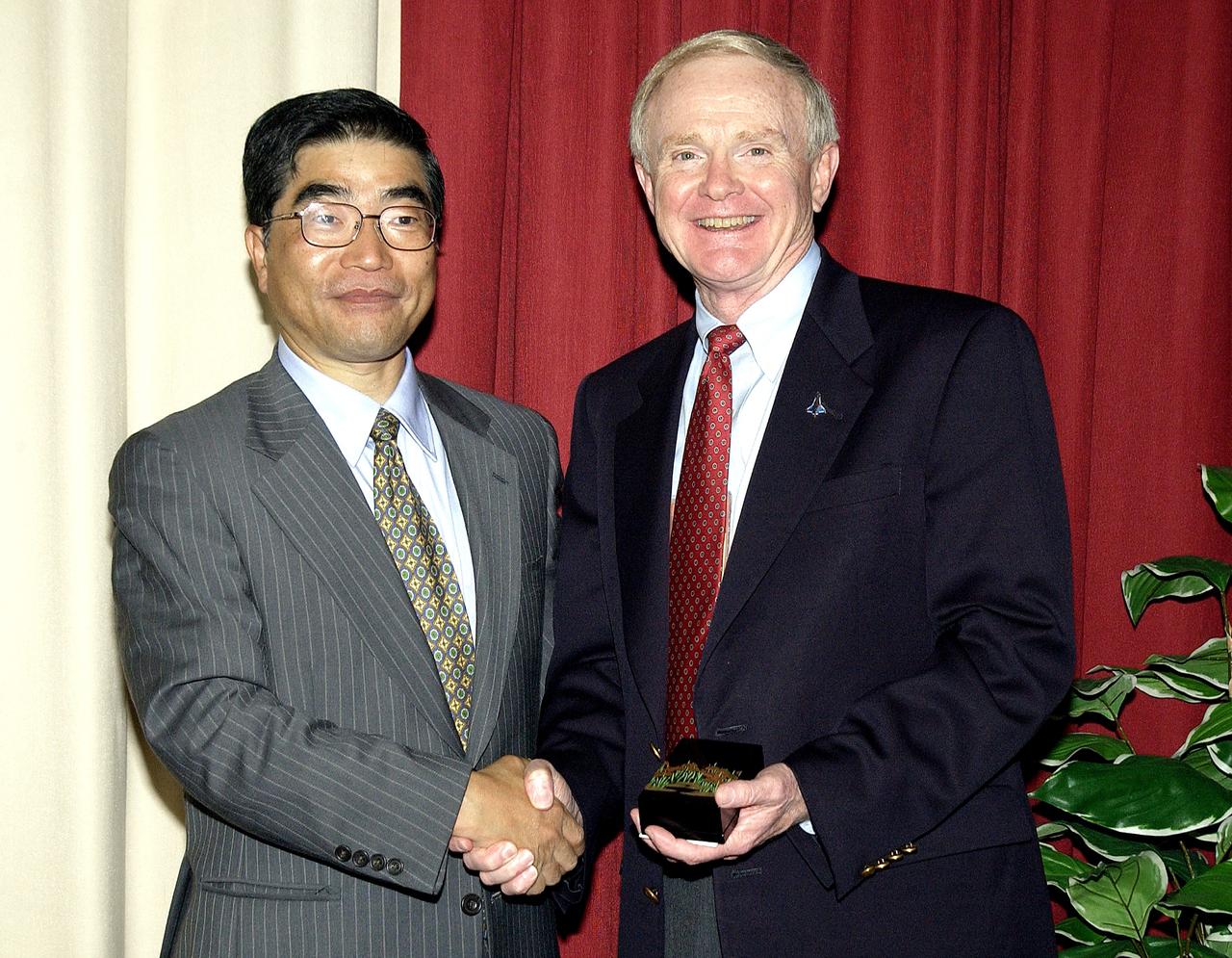 KENNEDY SPACE CENTER, FLA. -  Executive Director of NASDA Koji Yamamoto (left) is welcomed to KSC by Center Director Roy Bridges Jr. (right).  Mr. Yamamoto is at KSC for a welcome ceremony involving the arrival of the newest Space Station module, the Japanese Experiment Module/pressurized module.  His visit includes a tour of the Columbia Debris Hangar.