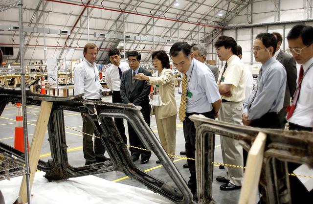 NASA image: KENNEDY SPACE CENTER, FLA. -  Shuttle Launch Director Mike Leinbach (left) accompanies Executive Director of NASDA Koji Yamamoto (third from left) and others visiting the Columbia Debris Hangar.  Mr. Yamamoto is at KSC for a welcome ceremony involving the arrival of the newest Space Station module, the Japanese Experiment Module/pressurized module.