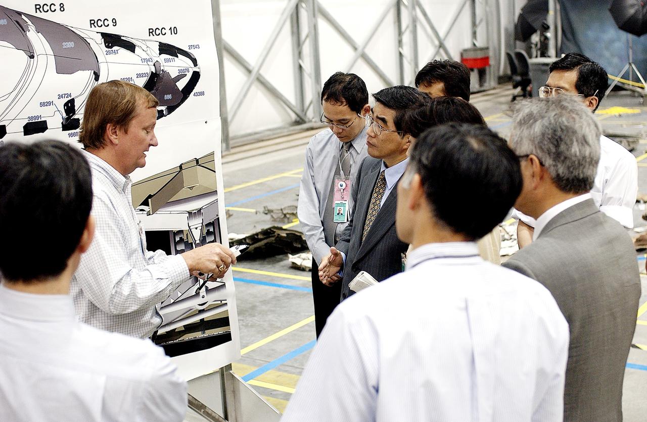 KENNEDY SPACE CENTER, FLA. -  Shuttle Launch Director Mike Leinbach (second from left) explains recovery and reconstruction efforts of Columbia to the Executive Director of NASDA Koji Yamamoto (fourth from left) and others visiting the Columbia Debris Hangar.   Mr. Yamamoto is at KSC for a welcome ceremony involving the arrival of the newest Space Station module, the Japanese Experiment Module/pressurized module.