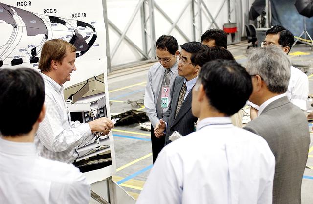NASA image: KENNEDY SPACE CENTER, FLA. -  Shuttle Launch Director Mike Leinbach (second from left) explains recovery and reconstruction efforts of Columbia to the Executive Director of NASDA Koji Yamamoto (fourth from left) and others visiting the Columbia Debris Hangar.   Mr. Yamamoto is at KSC for a welcome ceremony involving the arrival of the newest Space Station module, the Japanese Experiment Module/pressurized module.