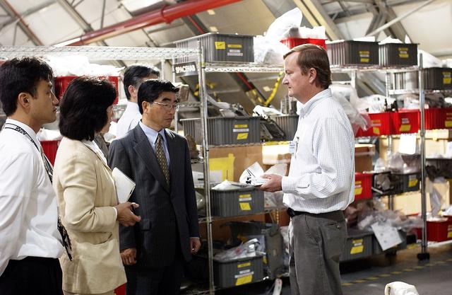 NASA image: KENNEDY SPACE CENTER, FLA. -  Shuttle Launch Director Mike Leinbach (right) explains recovery and reconstruction efforts of Columbia to the Executive Director of NASDA Koji Yamamoto (third from left) and others visiting the Columbia Debris Hangar.   Mr. Yamamoto is at KSC for a welcome ceremony involving the arrival of the newest Space Station module, the Japanese Experiment Module/pressurized module.