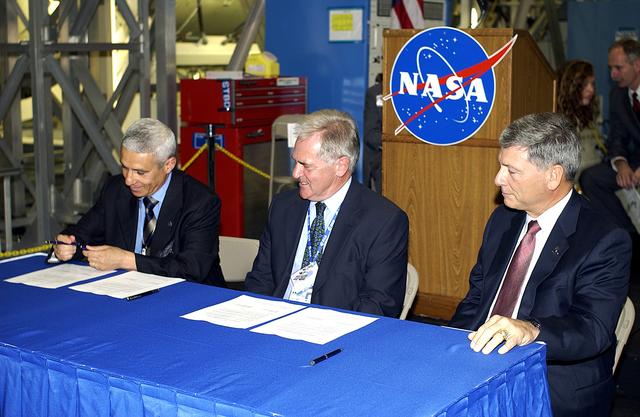 NASA image: KENNEDY SPACE CENTER, FLA. - Andrea Lorenzoni, International Space Station Program manager for Node 2, Italian Space Agency; Alan Thirkettle, International Space Station Program manager for Node 2, European Space Agency (ESA); and NASA’s Michael C. Kostelnik, deputy associate administrator for International Space Station and Shuttle Programs, sign documents officially transferring ownership of Node 2 between the ESA and NASA. The signing was part of a  ceremony highlighting the arrival of two major components of the International Space Station.  NASA's Node 2, built by the European Space Agency (ESA) in Italy, arrived at KSC on June 1. It will be the next pressurized module installed on the Station. The pressurized module (above right) of the Japanese Experiment Module (JEM),  named "Kibo" (Hope), arrived at KSC on June 4. It is Japan's primary contribution to the Station. Emceed by Lisa Malone (far left), deputy director of External Relations and Business Development at KSC, the ceremony also included these speakers: Center Director Roy Bridges Jr.; NASA’s William Gerstenmaier, International Space Station Program manager; and Kuniaki Shiraki, JEM Project manager, National Aerospace and Development Agency of Japan.