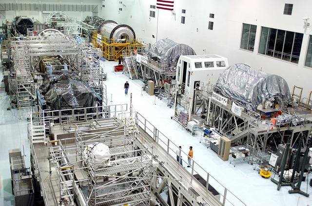 NASA image: KENNEDY SPACE CENTER, FLA. -  International Space Station elements being processed for launch on upcoming Space Shuttle flights line the walls of the high bay in the Space Station Processing Facility. NASA's Node 2, built by the European Space Agency (ESA) in Italy, arrived at KSC on June 1. It will be the next pressurized module installed on the Station. The pressurized module of the Japanese Experiment Module (JEM), named "Kibo" (Hope), arrived at KSC on June 4. It is Japan's primary contribution to the Station.