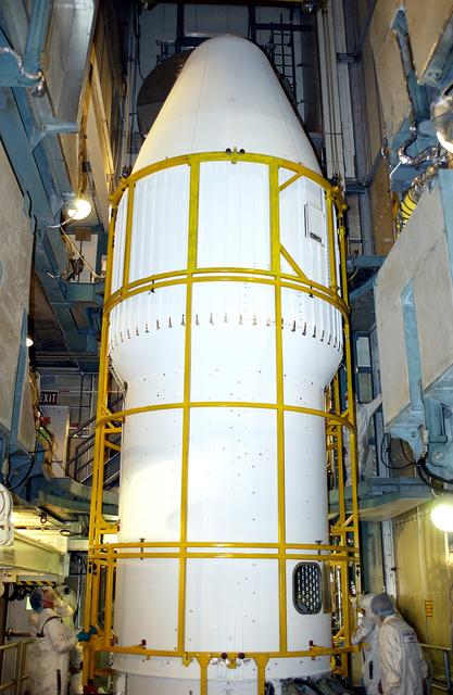NASA image: KENNEDY SPACE CENTER, FLA. - At Launch Complex 17-B, Cape Canaveral Air Force Station, workers complete the installation of the spacecraft fairing around the Mars Exploration Rover-1 (MER-B) for launch. The second of twin rovers being sent to Mars, it is equipped with a robotic arm, a drilling tool, three spectrometers, and four pairs of cameras that allow it to have a human-like, 3D view of the terrain. Each rover could travel as far as 100 meters in one day to act as Mars scientists' eyes and hands, exploring an environment where humans are not yet able to go. MER-B is scheduled to launch no earlier than June 28 at one of two available times, 11:56:16 p.m. EDT or 12:37:59 a.m. EDT.