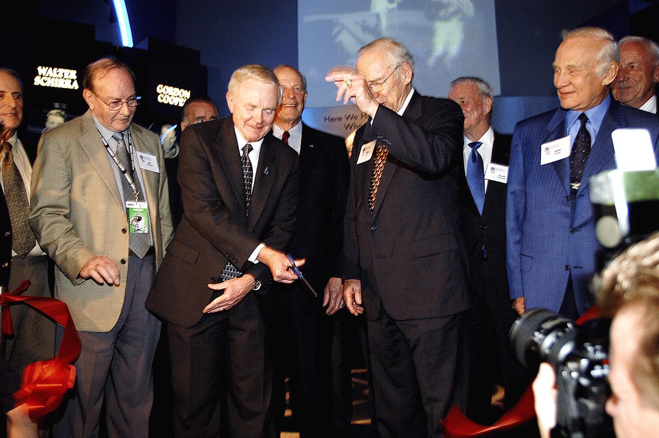 KENNEDY SPACE CENTER, FLA. -  Center Director and former astronaut Roy D. Bridges, Jr., (holding scissors) cuts the ribbon at a ceremony officially opening the U.S. Astronaut Hall of Fame as part of the Kennedy Space Center Visitor Complex.  Invited guests and dignitaries look on, such as former astronauts Edgar D. Mitchell on Bridges' left and James Lovell (hand up) and Buzz Aldrin on his right.  The ceremony was held in conjunction with the induction of four Space Shuttle astronauts into the Hall of Fame including Daniel Brandenstein, Robert "Hoot" Gibson, Story Musgrave, and Sally Ride.  Conceived by six of the Mercury Program astronauts, the U.S. Astronaut Hall of Fame opened in 1990 to provide a place where space travelers could be remembered for their participation and accomplishments in the U.S. space program.  The four new inductees join 48 previously honored astronauts from the ranks of the Gemini, Apollo, Skylab, Apollo-Soyuz, and Space Shuttle programs.