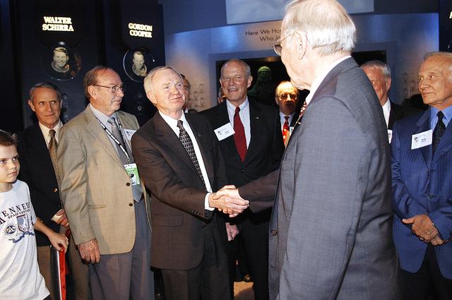 NASA image: KENNEDY SPACE CENTER, FLA. -  Center Director and former astronaut Roy D. Bridges, Jr., (left) shakes hands with former astronaut James Lovell following a ribbon cutting ceremony officially opening the U.S. Astronaut Hall of Fame as part of the Kennedy Space Center Visitor Complex.  Invited guests and dignitaries look on, such as, from left, former astronauts Edward G. Gibson, Edgar D. Mitchell, Jack R. Lousma, Frederick H. (Rick) Hauck, and Buzz Aldrin (far right).  The ceremony was held in conjunction with the induction of four Space Shuttle astronauts into the Hall of Fame including Daniel Brandenstein, Robert "Hoot" Gibson, Story Musgrave, and Sally Ride.  Conceived by six of the Mercury Program astronauts, the U.S. Astronaut Hall of Fame opened in 1990 to provide a place where space travelers could be remembered for their participation and accomplishments in the U.S. space program.  The four new inductees join 48 previously honored astronauts from the ranks of the Gemini, Apollo, Skylab, Apollo-Soyuz, and Space Shuttle programs.