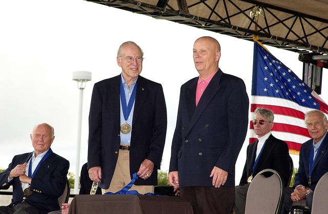 NASA image: KENNEDY SPACE CENTER, FLA. -  At the KSC Visitor Complex, former astronaut James A. Lovell (standing left) greets former astronaut Story Musgrave (standing right) at his induction ceremony into the U.S. Astronaut Hall of Fame. Also seated on the dais are, from left, former astronaut and Senator John H. Glenn, astronaut and Associate Director (Technical) of the Johnson Space Center John W. Young, and former astronaut Buzz Aldrin, all previously inducted into the Hall of Fame. Being inducted with Musgrave are Space Shuttle astronauts Daniel Brandenstein, Robert "Hoot" Gibson, and Sally Ride. Conceived by six of the Mercury Program astronauts, the U.S. Astronaut Hall of Fame opened in 1990 to provide a place where space travelers could be remembered for their participation and accomplishments in the U.S. space program. The four new inductees join 48 previously honored astronauts from the ranks of the Gemini, Apollo, Skylab, Apollo-Soyuz, and Space Shuttle programs.