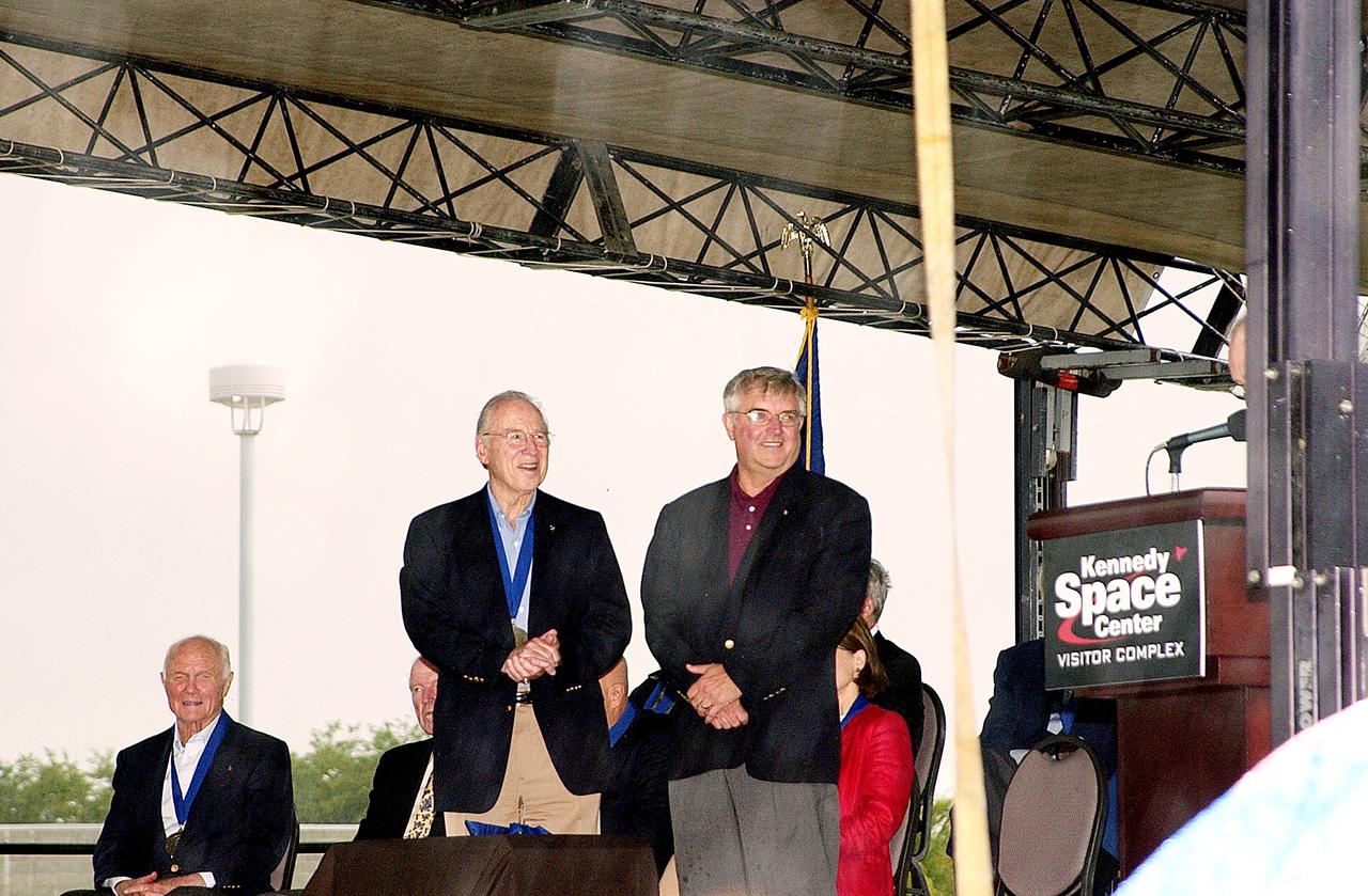 KENNEDY SPACE CENTER, FLA. -  At the KSC Visitor Complex, former astronaut Daniel Brandenstein (standing right) is presented to the audience at his induction ceremony into the U.S. Astronaut Hall of Fame. Also standing is former astronaut James A. Lovell.  Seated on the dais, from left, are former astronauts John H. Glenn and Gordon Cooper, both previously inducted into the Hall of Fame. Being inducted with Brandenstein are Space Shuttle astronauts Robert "Hoot" Gibson, Story Musgrave, and Sally K. Ride. Conceived by six of the Mercury Program astronauts, the U.S. Astronaut Hall of Fame opened in 1990 to provide a place where space travelers could be remembered for their participation and accomplishments in the U.S. space program. The four new inductees join 48 previously honored astronauts from the ranks of the Gemini, Apollo, Skylab, Apollo-Soyuz, and Space Shuttle programs.