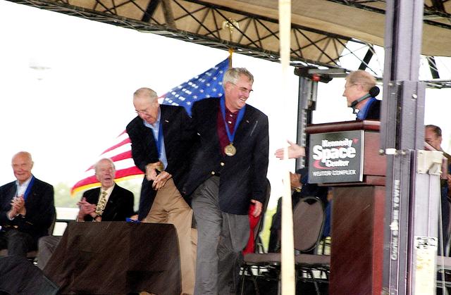 NASA image: KENNEDY SPACE CENTER, FLA. -  At the KSC Visitor Complex, former astronaut Frederick H. (Rick) Hauck (standing right) congratulates former astronaut Daniel Brandenstein (standing center) at his induction ceremony into the U.S. Astronaut Hall of Fame. Also standing is former astronaut James A. Lovell.  Seated on the dais, from left, are former astronauts John H. Glenn and Gordon Cooper, both previously inducted into the Hall of Fame. Being inducted with Brandenstein are Space Shuttle astronauts Robert "Hoot" Gibson, Story Musgrave, and Sally K. Ride. Conceived by six of the Mercury Program astronauts, the U.S. Astronaut Hall of Fame opened in 1990 to provide a place where space travelers could be remembered for their participation and accomplishments in the U.S. space program. The four new inductees join 48 previously honored astronauts from the ranks of the Gemini, Apollo, Skylab, Apollo-Soyuz, and Space Shuttle programs.