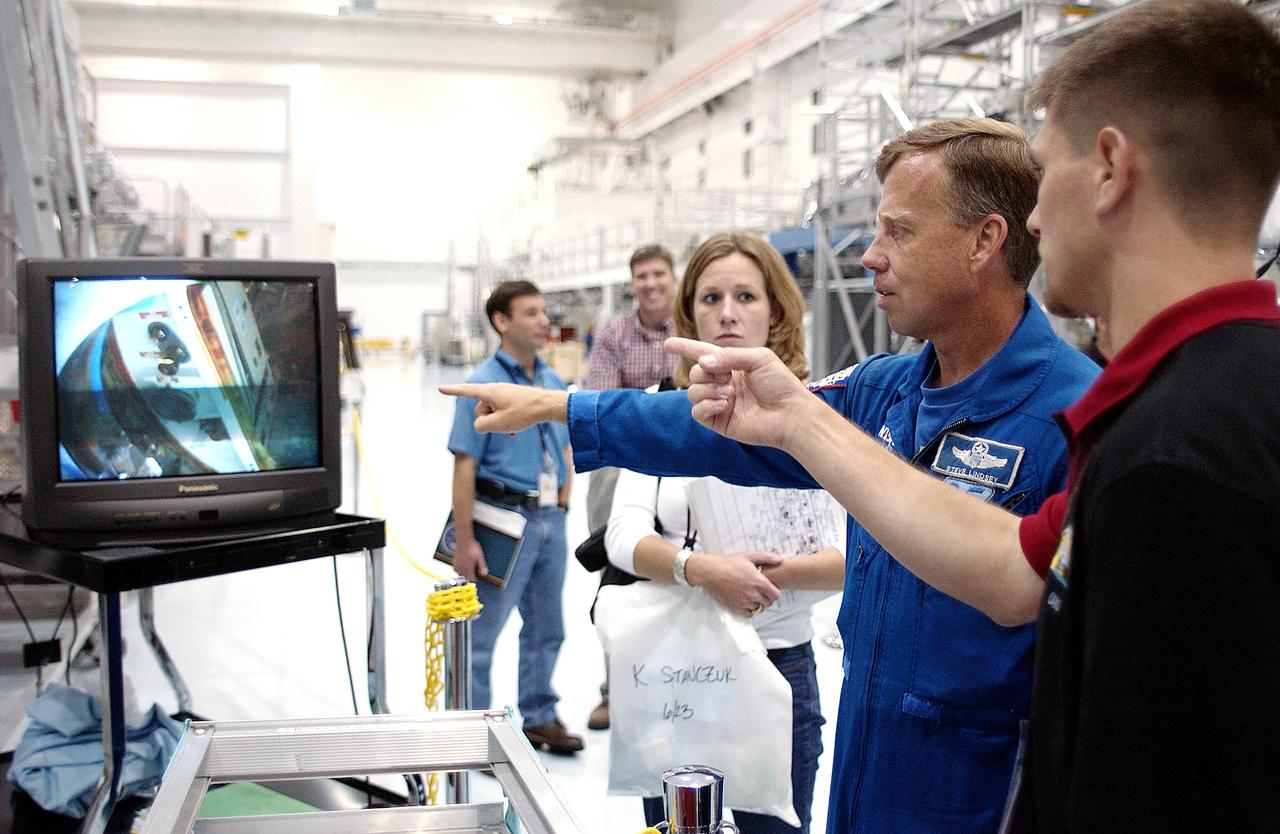 KENNEDY SPACE CENTER, FLA. -  NASA astronaut Steven W. Lindsey (second from right) views the interior of the pressurized module of the Japanese Experiment Module (JEM) on a television monitor in the Space Station Processing Facility.  This major component of JEM, named "Kibo" (Hope), is Japan's primary contribution to the International Space Station and arrived at KSC on June 4.  Lindsey is assigned to command STS-119, an upcoming Space Shuttle flight to the Station.
