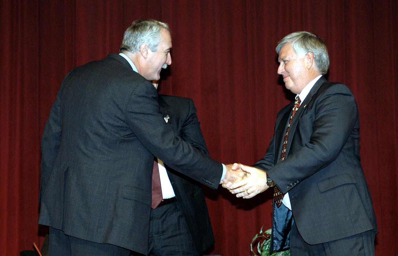 KENNEDY SPACE CENTER, FLA. -  NASA Administrator Sean O'Keefe (left) congratulates James W. Kennedy (right)  before a group of KSC employees assembled in the KSC Training Auditorium.  The occasion is the announcement of Kennedy as the next director of the NASA Kennedy Space Center (KSC) in Florida. Kennedy has served as KSC's deputy director since November 2002. He will succeed KSC Director Roy D. Bridges, who was appointed on June 13 to lead NASA's Langley Research Center, Hampton, Va.