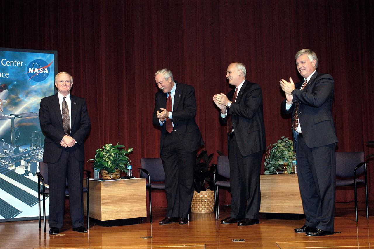 KENNEDY SPACE CENTER, FLA. -  KSC Center Director Roy D. Bridges receives the applause of NASA officials and a group of KSC employees assembled in the KSC Training Auditorium.   From left are Bridges, NASA Administrator Sean O'Keefe, NASA Associate Administrator of Space Flight William F. Readdy, and KSC Deputy Director James W. Kennedy. The occasion is the announcement of Kennedy as the next director of the NASA Kennedy Space Center (KSC) in Florida. Kennedy has served as KSC's deputy director since November 2002. He will succeed Bridges, who was appointed on June 13 to lead NASA's Langley Research Center, Hampton, Va.