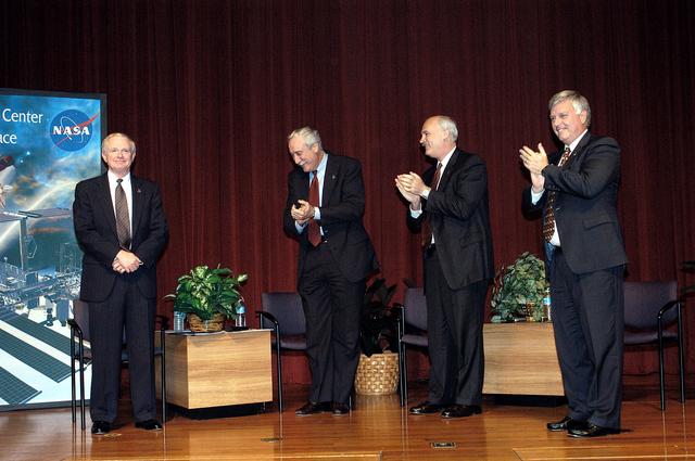KENNEDY SPACE CENTER, FLA. -  KSC Center Director Roy D. Bridges receives the applause of NASA officials and a group of KSC employees assembled in the KSC Training Auditorium.   From left are Bridges, NASA Administrator Sean O'Keefe, NASA Associate Administrator of Space Flight William F. Readdy, and KSC Deputy Director James W. Kennedy. The occasion is the announcement of Kennedy as the next director of the NASA Kennedy Space Center (KSC) in Florida. Kennedy has served as KSC's deputy director since November 2002. He will succeed Bridges, who was appointed on June 13 to lead NASA's Langley Research Center, Hampton, Va.