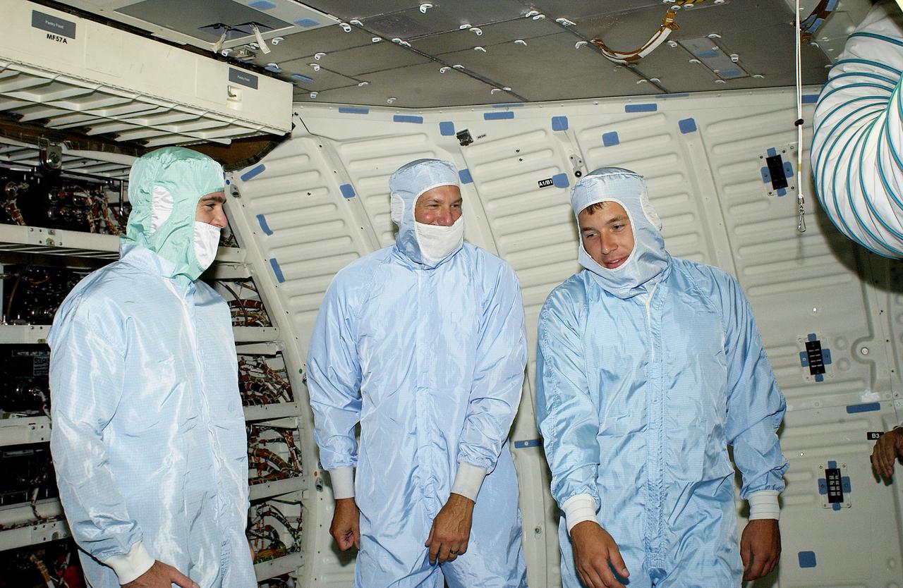 Three NASCAR drivers, (from left) Jimmie Johnson, Dale Jarrett and Ryan Newman, get a close look at the orbiter Endeavour during their tour of KSC. The men are scheduled to drive in the Pepsi 400 auto race being held July 5 at the Daytona International Speedway, Daytona Beach.