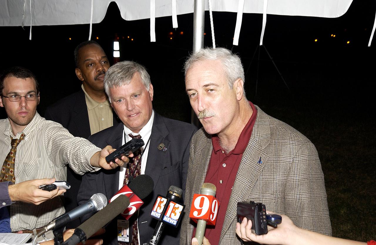 KENNEDY SPACE CENTER, FLA. - Newly appointed KSC Director James W. Kennedy (second from left) and NASA Administrator Sean O'Keefe (right) talk to the media following the launch of the Mars Exploration Rover "Opportunity" at the Trident Basin berm press site at Cape Canaveral Air Force Station.