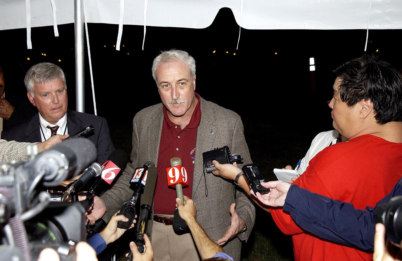 KENNEDY SPACE CENTER, FLA. - Newly appointed KSC Director James W. Kennedy (left) and NASA Administrator Sean O'Keefe (center) talk to the media following the launch of the Mars Exploration Rover "Opportunity" at the Trident Basin berm press site at Cape Canaveral Air Force Station.