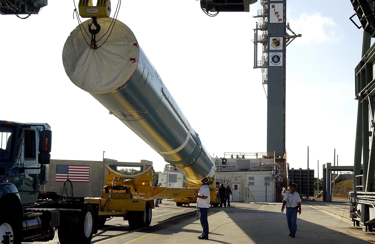 KENNEDY SPACE CENTER, FLA. -   On Launch Complex 17-B, Cape Canaveral Air Force Station, the first stage of a Delta II rocket is raised off the transporter before lifting and moving it into the mobile service tower.  The rocket is being erected to launch the Space InfraRed Telescope Facility (SIRTF).  Consisting of an 0.85-meter telescope and three cryogenically cooled science instruments, SIRTF is one of NASA's largest infrared telescopes to be launched.  SIRTF will obtain images and spectra by detecting the infrared energy, or heat, radiated by objects in space. Most of this infrared radiation is blocked by the Earth's atmosphere and cannot be observed from the ground.