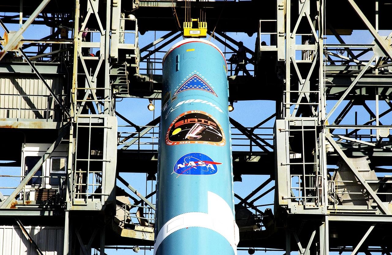 KENNEDY SPACE CENTER, FLA. -   On Launch Complex 17-B, Cape Canaveral Air Force Station, the first stage of a Delta II rocket is nearly erect for its move into the mobile service tower.  The rocket is being erected to launch the Space InfraRed Telescope Facility (SIRTF).  Consisting of an 0.85-meter telescope and three cryogenically cooled science instruments, SIRTF is one of NASA's largest infrared telescopes to be launched.  SIRTF will obtain images and spectra by detecting the infrared energy, or heat, radiated by objects in space. Most of this infrared radiation is blocked by the Earth's atmosphere and cannot be observed from the ground.