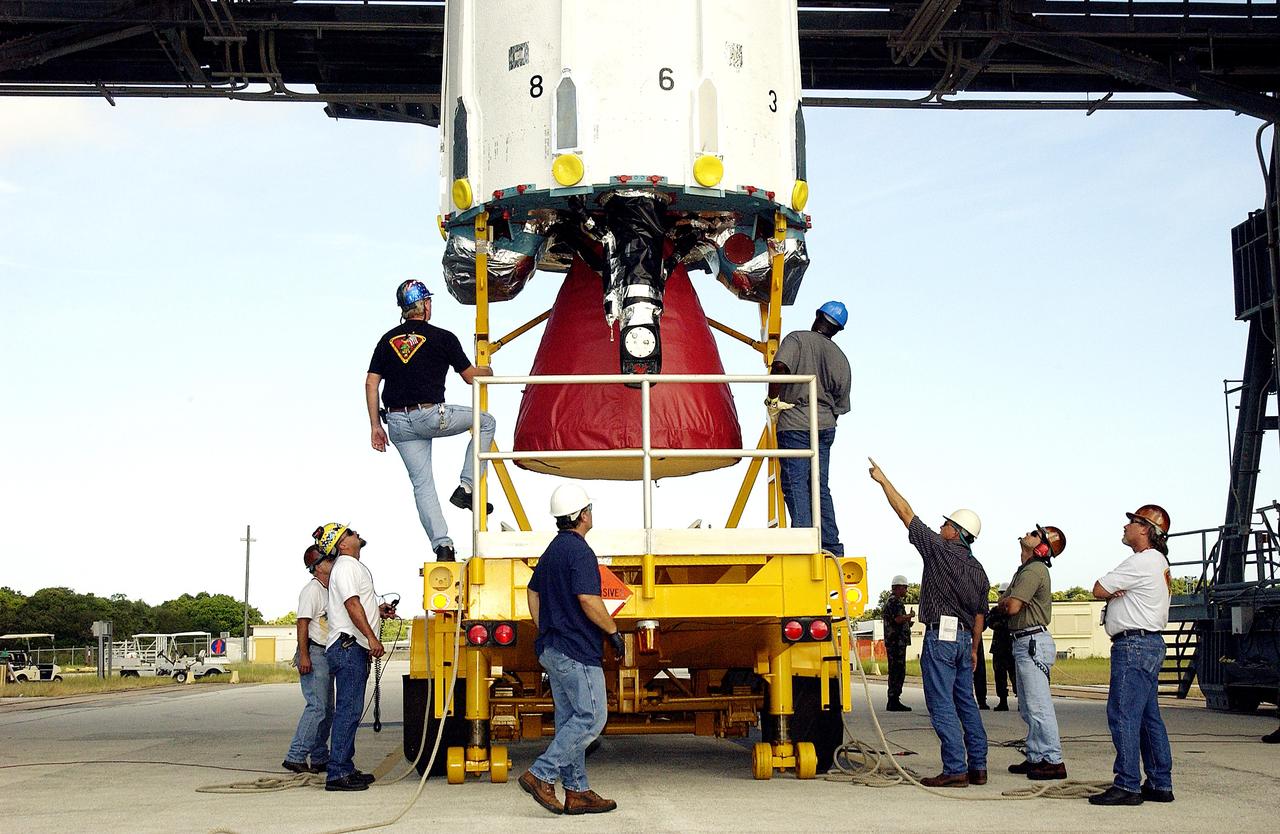 KENNEDY SPACE CENTER, FLA. -  Workers on Launch Complex 17-B, Cape Canaveral Air Force Station, prepare the first stage of a Delta II rocket for its lift up the mobile service tower.  The rocket is being erected to launch the Space InfraRed Telescope Facility (SIRTF).  Consisting of an 0.85-meter telescope and three cryogenically cooled science instruments, SIRTF is one of NASA's largest infrared telescopes to be launched.  SIRTF will obtain images and spectra by detecting the infrared energy, or heat, radiated by objects in space. Most of this infrared radiation is blocked by the Earth's atmosphere and cannot be observed from the ground.