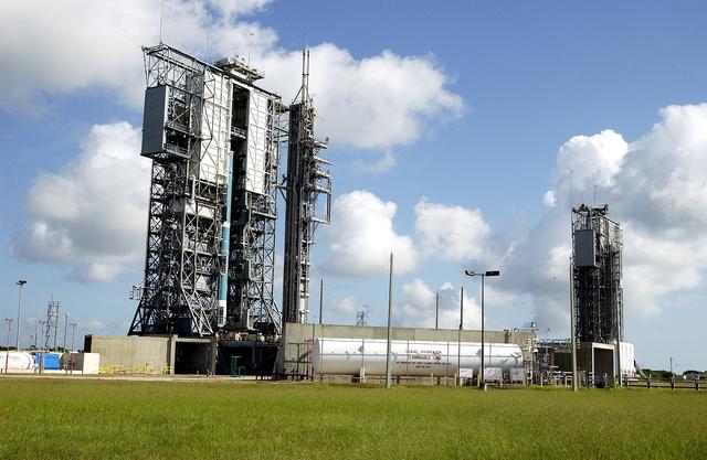 NASA image: KENNEDY SPACE CENTER, FLA. -  On Launch Complex 17-B, Cape Canaveral Air Force Station, the first stage of a Delta II rocket is lifted up the mobile service tower.  In the background is pad 17-A.   The rocket is being erected to launch the Space InfraRed Telescope Facility (SIRTF).  Consisting of an 0.85-meter telescope and three cryogenically cooled science instruments, SIRTF is one of NASA's largest infrared telescopes to be launched.  SIRTF will obtain images and spectra by detecting the infrared energy, or heat, radiated by objects in space. Most of this infrared radiation is blocked by the Earth's atmosphere and cannot be observed from the ground.