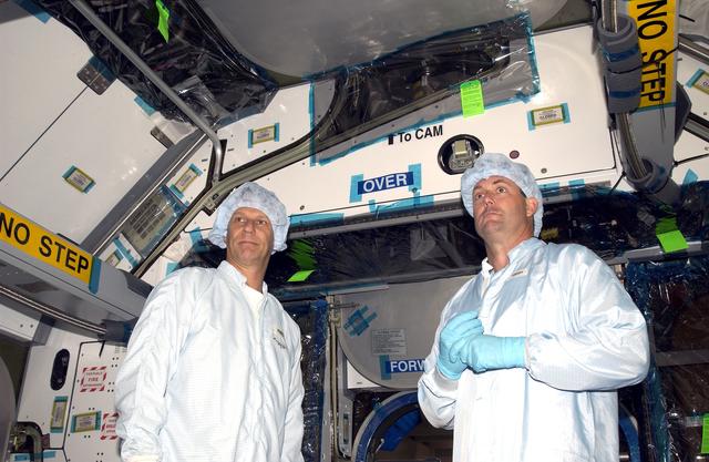 NASA image: KENNEDY SPACE CENTER, FLA. -    STS-120 Mission Specialists Piers Sellers and Michael Foreman check out the inside of the Japanese Experiment Module (JEM) Pressurized Module located in the Space Station Processing Facility. Known as Kibo, the JEM consists of six components: two research facilities -- the Pressurized Module and Exposed Facility; a Logistics Module attached to each of them; a Remote Manipulator System; and an Inter-Orbit Communication System unit. Kibo also has a scientific airlock through which experiments are transferred and exposed to the external environment of space. The various components of JEM will be assembled in space over the course of three Space Shuttle missions.  The STS-120 mission will deliver the second of three Station connecting modules, Node 2, which attaches to the end of U.S. Lab.  It will provide attach locations for the JEM, European laboratory, the Centrifuge Accommodation Module and later Multi-Purpose Logistics Modules.  The addition of Node 2 will complete the U.S. core of the International Space Station.