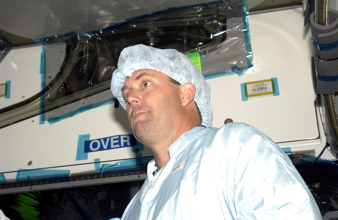 KENNEDY SPACE CENTER, FLA. -   In the Space Station Processing Facility, STS-120 Mission Specialist Michael Foreman looks over the Japanese Experiment Module (JEM) Pressurized Module. Known as Kibo, the JEM consists of six components: two research facilities -- the Pressurized Module and Exposed Facility; a Logistics Module attached to each of them; a Remote Manipulator System; and an Inter-Orbit Communication System unit. Kibo also has a scientific airlock through which experiments are transferred and exposed to the external environment of space. The various components of JEM will be assembled in space over the course of three Space Shuttle missions.  The STS-120 mission will deliver the second of three Station connecting modules, Node 2, which attaches to the end of U.S. Lab.  It will provide attach locations for the Japanese laboratory, European laboratory, the Centrifuge Accommodation Module and later Multi-Purpose Logistics Modules.  The addition of Node 2 will complete the U.S. core of the International Space Station.