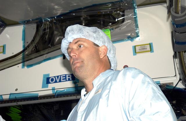 NASA image: KENNEDY SPACE CENTER, FLA. -   In the Space Station Processing Facility, STS-120 Mission Specialist Michael Foreman looks over the Japanese Experiment Module (JEM) Pressurized Module. Known as Kibo, the JEM consists of six components: two research facilities -- the Pressurized Module and Exposed Facility; a Logistics Module attached to each of them; a Remote Manipulator System; and an Inter-Orbit Communication System unit. Kibo also has a scientific airlock through which experiments are transferred and exposed to the external environment of space. The various components of JEM will be assembled in space over the course of three Space Shuttle missions.  The STS-120 mission will deliver the second of three Station connecting modules, Node 2, which attaches to the end of U.S. Lab.  It will provide attach locations for the Japanese laboratory, European laboratory, the Centrifuge Accommodation Module and later Multi-Purpose Logistics Modules.  The addition of Node 2 will complete the U.S. core of the International Space Station.