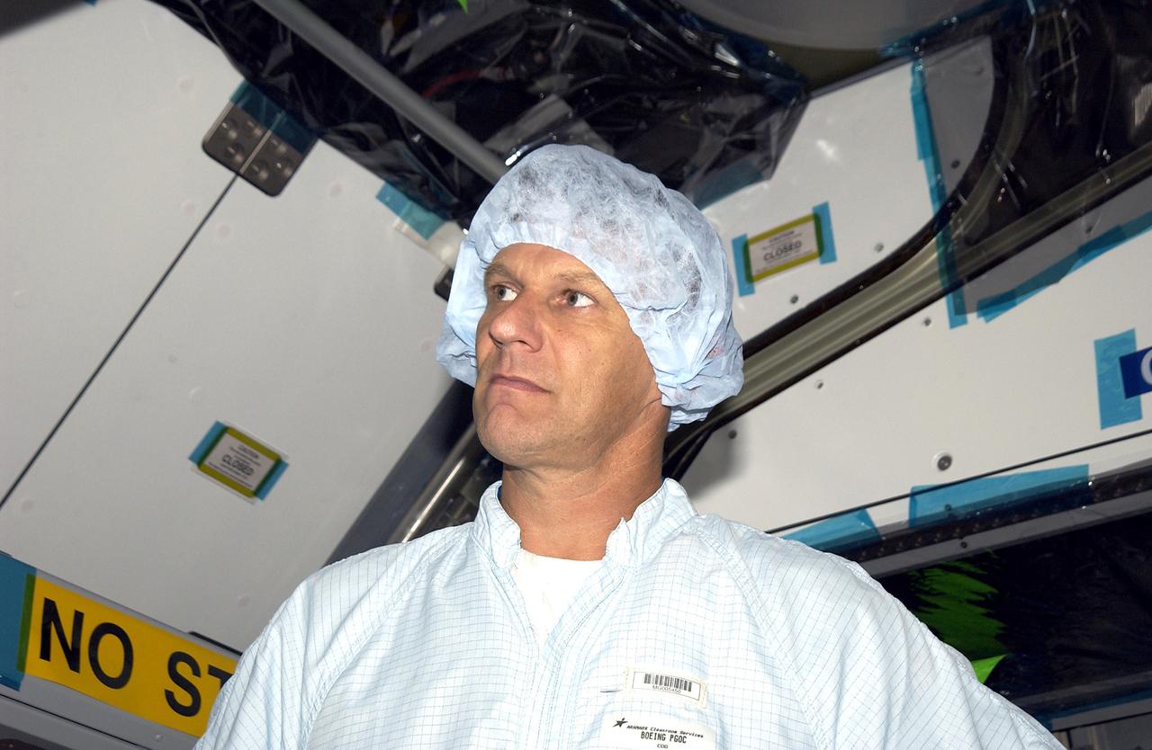 KENNEDY SPACE CENTER, FLA. -  In the Space Station Processing Facility, STS-120 Mission Specialist Piers Sellers looks over the Japanese Experiment Module (JEM) Pressurized Module. Known as Kibo, the JEM consists of six components: two research facilities -- the Pressurized Module and Exposed Facility; a Logistics Module attached to each of them; a Remote Manipulator System; and an Inter-Orbit Communication System unit. Kibo also has a scientific airlock through which experiments are transferred and exposed to the external environment of space. The various components of JEM will be assembled in space over the course of three Space Shuttle missions.   The STS-120 mission will deliver the second of three Station connecting modules, Node 2, which attaches to the end of U.S. Lab.  It will provide attach locations for the Japanese laboratory, European laboratory, the Centrifuge Accommodation Module and later Multi-Purpose Logistics Modules.  The addition of Node 2 will complete the U.S. core of the International Space Station.
