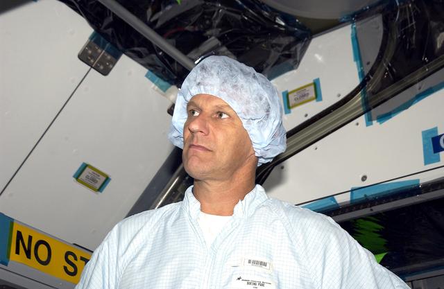 NASA image: KENNEDY SPACE CENTER, FLA. -  In the Space Station Processing Facility, STS-120 Mission Specialist Piers Sellers looks over the Japanese Experiment Module (JEM) Pressurized Module. Known as Kibo, the JEM consists of six components: two research facilities -- the Pressurized Module and Exposed Facility; a Logistics Module attached to each of them; a Remote Manipulator System; and an Inter-Orbit Communication System unit. Kibo also has a scientific airlock through which experiments are transferred and exposed to the external environment of space. The various components of JEM will be assembled in space over the course of three Space Shuttle missions.   The STS-120 mission will deliver the second of three Station connecting modules, Node 2, which attaches to the end of U.S. Lab.  It will provide attach locations for the Japanese laboratory, European laboratory, the Centrifuge Accommodation Module and later Multi-Purpose Logistics Modules.  The addition of Node 2 will complete the U.S. core of the International Space Station.
