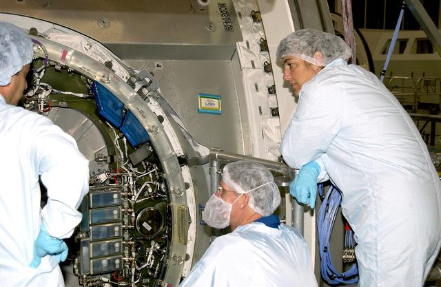 KENNEDY SPACE CENTER, FLA. -  In the Space Station Processing Facility, STS-115 Mission Specialists Joseph Tanner (center) and Heidemarie Stefanyshyn-Piper (right)  look at the inside of the Japanese Experiment Module (JEM) Pressurized Module. Known as Kibo, the JEM consists of six components: two research facilities -- the Pressurized Module and Exposed Facility; a Logistics Module attached to each of them; a Remote Manipulator System; and an Inter-Orbit Communication System unit. Kibo also has a scientific airlock through which experiments are transferred and exposed to the external environment of space. The various components of JEM will be assembled in space over the course of three Space Shuttle missions.    The STS-115  mission will deliver the second port truss segment, the P3/P4 Truss, to attach to the first port truss segment, the P1 Truss, as well as deploy solar array sets 2A and 4A..  The crew is scheduled to activate and check out the Solar Alpha Rotary Joint (SARJ) and deploy the P4 Truss radiator.