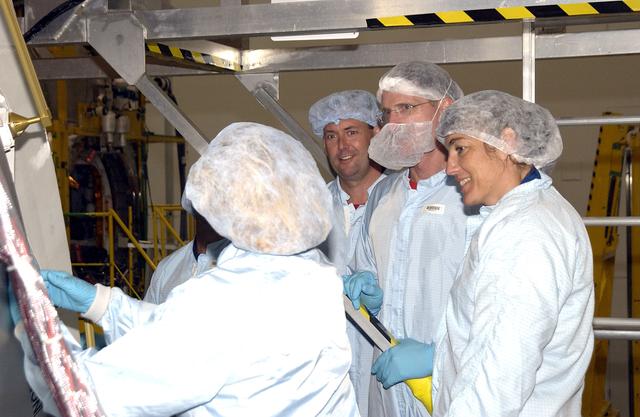 KENNEDY SPACE CENTER, FLA. - In the Space Station Processing Facility, STS-120 Mission Specialists Michael Foreman (third from right) and STS-115 Mission Specialists Joseph Tanner (second from right) and Heidemarie Stefanyshyn-Piper (right) look over the Japanese Experiment Module (JEM) Pressurized Module. Known as Kibo, the JEM consists of six components: two research facilities -- the Pressurized Module and Exposed Facility; a Logistics Module attached to each of them; a Remote Manipulator System; and an Inter-Orbit Communication System unit. Kibo also has a scientific airlock through which experiments are transferred and exposed to the external environment of space. The various components of JEM will be assembled in space over the course of three Space Shuttle missions.  STS-115 will deliver the second port truss segment, the P3/P4 Truss, to attach to the first port truss segment, the P1 Truss, as well as deploy solar array sets 2A and 4A.. STS-120 will deliver the second of three Station connecting modules, Node 2, which attaches to the end of U.S. Lab.  It will provide attach locations for the Japanese laboratory, European laboratory, the Centrifuge  Accommodation Module and later Multi-Purpose Logistics Modules.  The addition of Node 2 will complete the U.S. core of the International Space Station.
