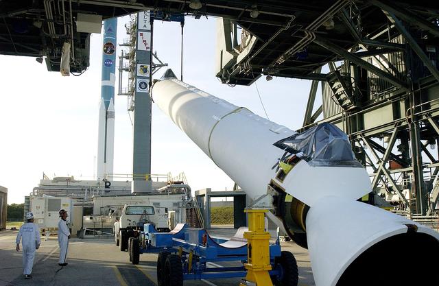 NASA image: KENNEDY SPACE CENTER, FLA. -   A solid rocket booster (SRB) for the Delta II Heavy rocket that will launch the Space Infrared Telescope Facility (SIRTF) is lifted off its transporter on Launch Complex 17-B, Cape Canaveral Air Force Station.  The SRB will be added to the launch vehicle in the background.  The Delta II Heavy features nine 46-inch-diameter, stretched SRBs.  SIRTF, consisting of three cryogenically cooled science instruments and an 0.85-meter telescope, is one of NASA's largest infrared telescopes to be launched.  SIRTF will obtain images and spectra by detecting the infrared energy, or heat, radiated by objects in space. Most of this infrared radiation is blocked by the Earth's atmosphere and cannot be observed from the ground.