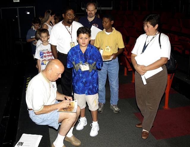 NASA image: KENNEDY SPACE CENTER, FLA.  -   Former astronaut Story Musgrave signs autographs for employees’ children after his presentation during a welcome ceremony in the IMAX Theatre, KSC Visitor Complex.  Employees were invited to share their work experience with their children for Take Our Children to Work Day.