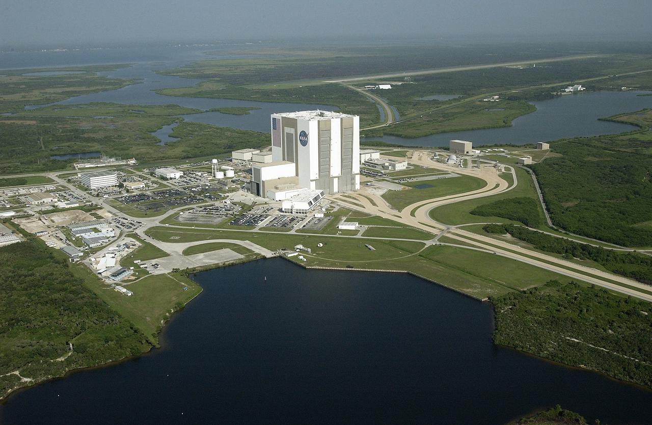 CAPE CANAVERAL, Fla. -- This view shows much of the Launch Complex 39 Area stretching beyond the Turn Basin in the foreground.  At center is the 525-foot-tall Vehicle Assembly Building, with the starting and endpoint of the crawlerway that leads to both launch pads.  The low building attached to the VAB is the Launch Control Center.  At center left is the Operations and Support Building.  At upper right can be seen the runway at the Shuttle Landing Facility.  Surrounding waters are part of Banana Creek.         Photo credit: NASA