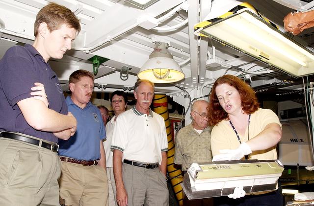 NASA image: KENNEDY SPACE CENTER, FLA.  -  NASA worker Joy Huff (right) shows a leading edge subsystems (LESS) with tile bonded to it to members of the Stafford-Covey Return to Flight Task Group (SCTG).  From left are Dr. Amy Donahue, David Lengyel, Dr. Kathryn Clark,  Richard Covey, former Space Shuttle commander, and William Wegner.  Covey is co-chair of the SCTG along with Thomas P. Stafford, Apollo commander.  Chartered by NASA Administrator Sean O’Keefe, the task group will perform an independent assessment of NASA’s implementation of the final recommendations by the Columbia Accident Investigation Board.