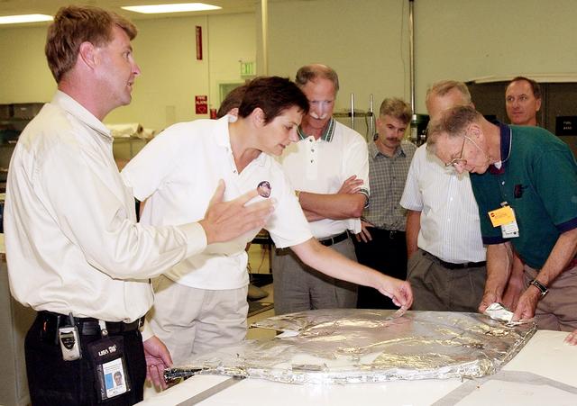 NASA image: KENNEDY SPACE CENTER, FLA.  -  Martin Wilson, with United Space Alliance, describes an orbiter’s Thermal Protection System for members of the Stafford-Covey Return to Flight Task Group (SCTG).  Handling some of the blanket insulation are Dr. Kathryn Clark and Joe Engle.  Third from left is Richard Covey, former Space Shuttle commander, who is co-chair of the  SCTG, along with Thomas P. Stafford, Apollo commander.  Chartered by NASA Administrator Sean O’Keefe, the task group will perform an independent assessment of NASA’s implementation of the final recommendations by the Columbia Accident Investigation Board.