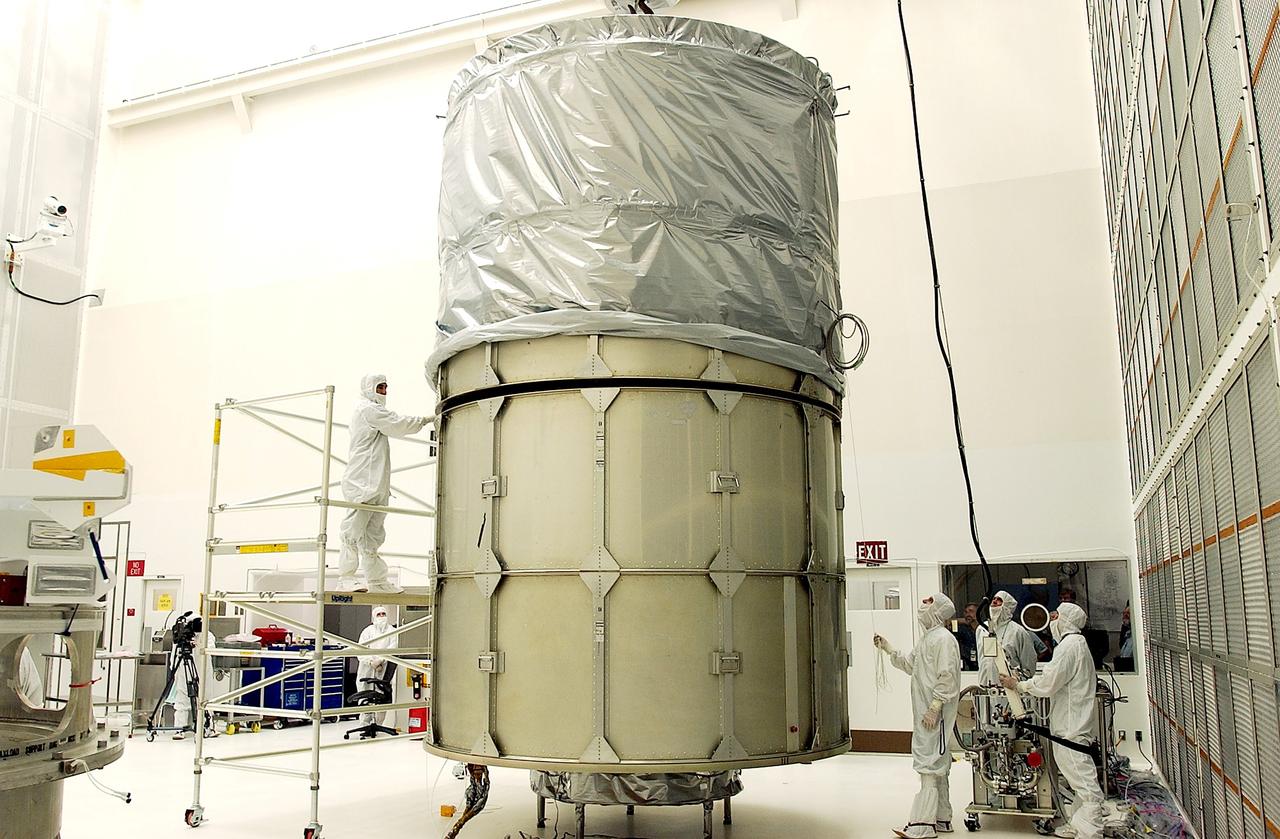 KENNEDY SPACE CENTER, FLA.  -  In Hangar A&E, Cape Canaveral Air Force Station, the upper canister is mated to the middle panels around the Space Infrared Telescope Facility (SIRTF).  The spacecraft will be transported to Launch Complex 17-B for mating with its launch vehicle, the Delta II rocket.   SIRTF consists of three cryogenically cooled science instruments and an 0.85-meter telescope, and is one of NASA's largest infrared telescopes to be launched.  SIRTF will obtain images and spectra by detecting the infrared energy, or heat, radiated by objects in space. Most of this infrared radiation is blocked by the Earth's atmosphere and cannot be observed from the ground.