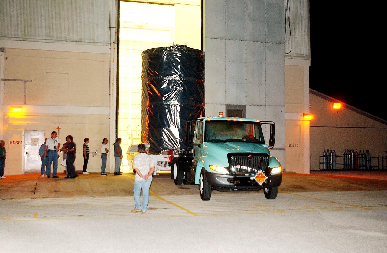 KENNEDY SPACE CENTER, FLA.  -  The Space Infrared Telescope Facility (SIRTF) is rolled out of the hangar at Cape Canaveral Air Force Station during pre-dawn hours.  It is being transported to Launch Pad 17-B where it will be lifted into the mobile service tower and prepared for launch.  SIRTF consists of three cryogenically cooled science instruments and an 0.85-meter telescope, and is one of NASA’s largest infrared telescopes to be launched.  It is the fourth and final element in NASA’s family of orbiting “Great Observatories.”  SIRTF will obtain images and spectra by detecting the infrared energy, or heat, radiated by objects in space. Most of this infrared radiation is blocked by the Earth's atmosphere and cannot be observed from the ground.