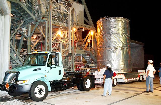 NASA image: KENNEDY SPACE CENTER, FLA.  -  Before dawn, the Space Infrared Telescope Facility (SIRTF) arrives at Launch Pad 17-B, Cape Canaveral Air Force Station, where it will be lifted into the mobile service tower and prepared for launch.  SIRTF consists of three cryogenically cooled science instruments and an 0.85-meter telescope, and is one of NASA’s largest infrared telescopes to be launched.  It is the fourth and final element in NASA’s family of orbiting “Great Observatories.”  SIRTF will obtain images and spectra by detecting the infrared energy, or heat, radiated by objects in space. Most of this infrared radiation is blocked by the Earth's atmosphere and cannot be observed from the ground.