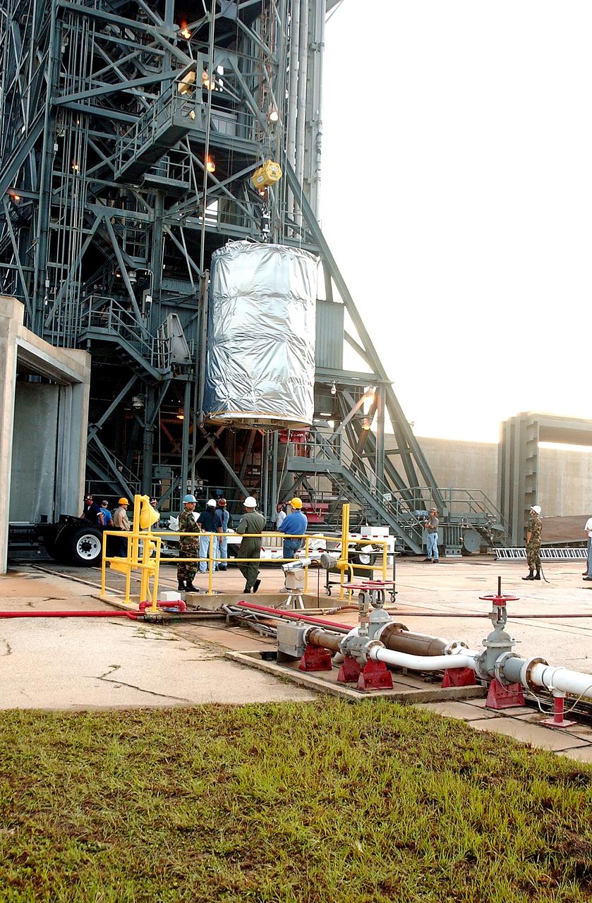 KENNEDY SPACE CENTER, FLA.  -  After dawn,  the Space Infrared Telescope Facility (SIRTF) is lifted up the mobile service tower on Launch Pad 17-B, Cape Canaveral Air Force Station.  SIRTF will be attached to the Delta II rocket and encapsulated in its fairing before launch.   Consisting of three cryogenically cooled science instruments and an 0.85-meter telescope, SIRTF is one of NASA’s largest infrared telescopes to be launched.  It is the fourth and final element in NASA’s family of orbiting “Great Observatories.”  SIRTF will obtain images and spectra by detecting the infrared energy, or heat, radiated by objects in space. Most of this infrared radiation is blocked by the Earth's atmosphere and cannot be observed from the ground.