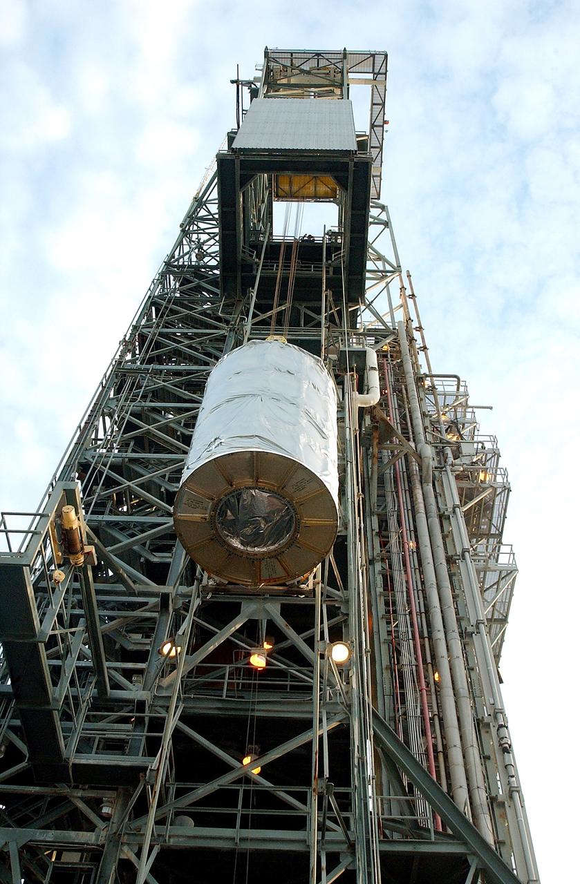 KENNEDY SPACE CENTER, FLA.  -  Viewed from below, the Space Infrared Telescope Facility (SIRTF) is lifted up the mobile service tower on Launch Pad 17-B, Cape Canaveral Air Force Station.  SIRTF will be attached to the Delta II rocket and encapsulated in its fairing before launch.   Consisting of three cryogenically cooled science instruments and an 0.85-meter telescope, SIRTF is one of NASA’s largest infrared telescopes to be launched.  It is the fourth and final element in NASA’s family of orbiting “Great Observatories.”  SIRTF will obtain images and spectra by detecting the infrared energy, or heat, radiated by objects in space. Most of this infrared radiation is blocked by the Earth's atmosphere and cannot be observed from the ground.
