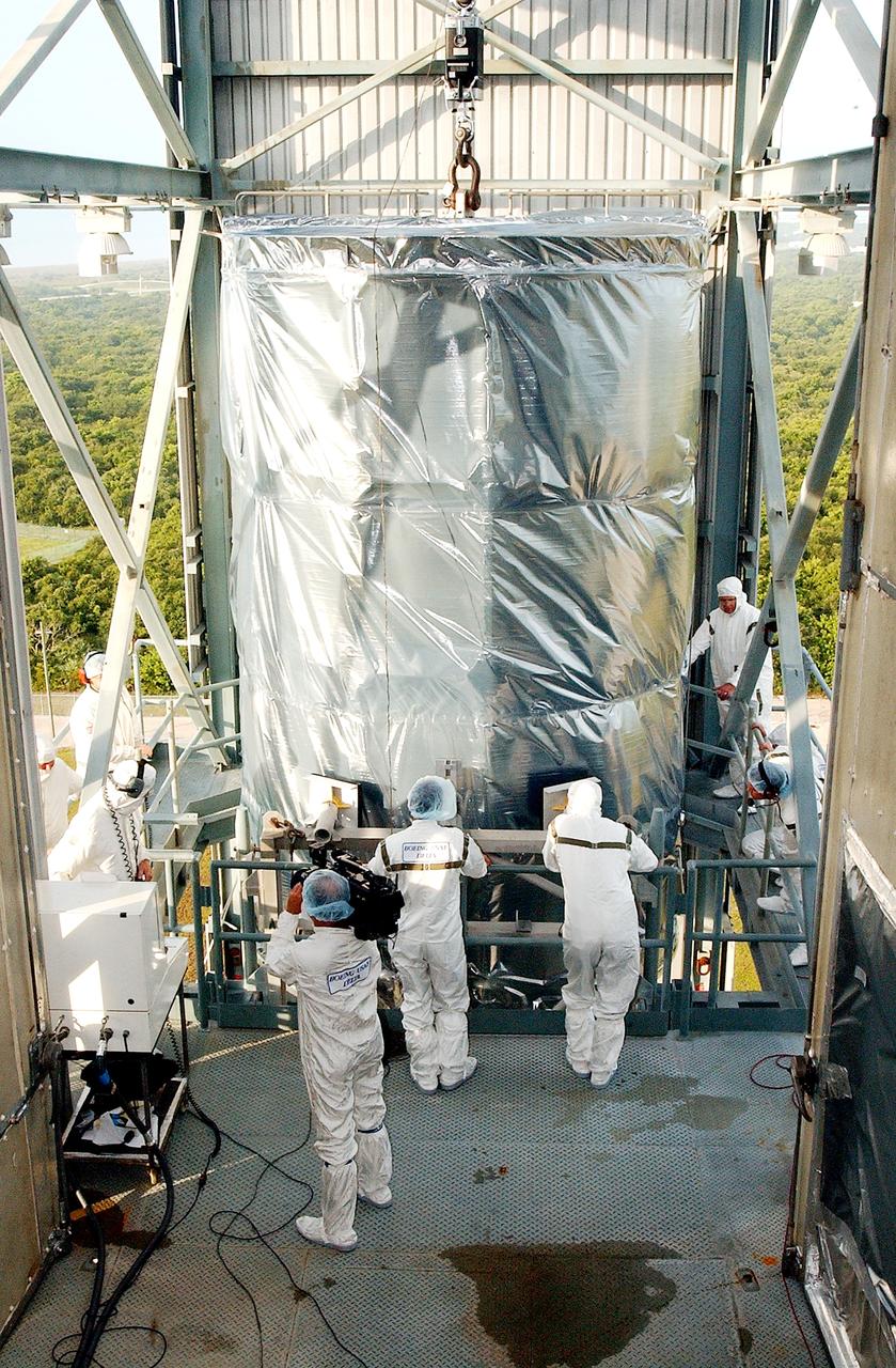 KENNEDY SPACE CENTER, FLA.  -  Workers on the mobile service tower on Launch Pad 17-B, Cape Canaveral Air Force Station, wait for the Space Infrared Telescope Facility (SIRTF) to reach their level.  SIRTF will be attached to the Delta II rocket and encapsulated in its fairing before launch.   Consisting of three cryogenically cooled science instruments and an 0.85-meter telescope, SIRTF is one of NASA’s largest infrared telescopes to be launched.  It is the fourth and final element in NASA’s family of orbiting “Great Observatories.”  SIRTF will obtain images and spectra by detecting the infrared energy, or heat, radiated by objects in space. Most of this infrared radiation is blocked by the Earth's atmosphere and cannot be observed from the ground.