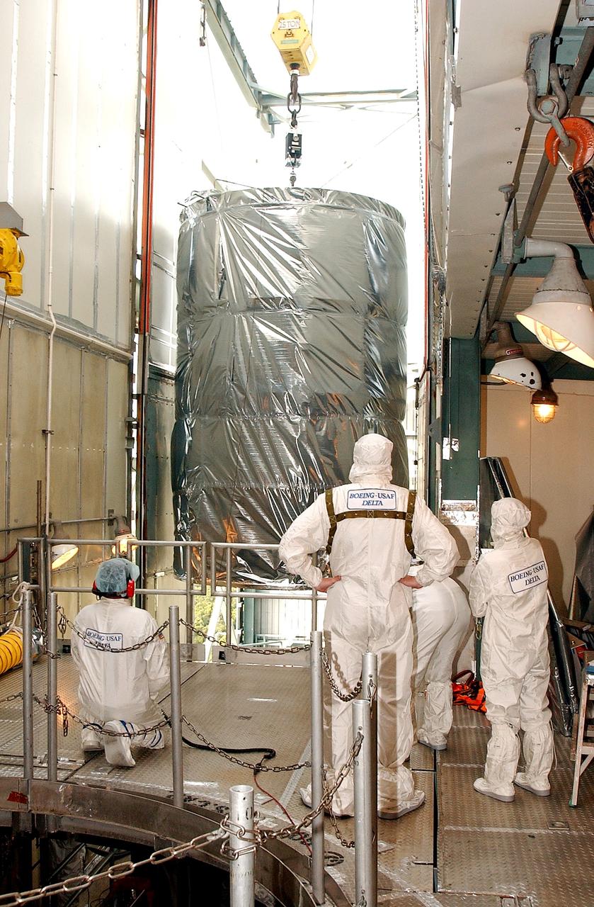 KENNEDY SPACE CENTER, FLA.  -  Workers on the mobile service tower on Launch Pad 17-B, Cape Canaveral Air Force Station, watch as the Space Infrared Telescope Facility (SIRTF) clears the platform.   SIRTF will be attached to the Delta II rocket and encapsulated in its fairing before launch.   Consisting of three cryogenically cooled science instruments and an 0.85-meter telescope, SIRTF is one of NASA’s largest infrared telescopes to be launched.  It is the fourth and final element in NASA’s family of orbiting “Great Observatories.”  SIRTF will obtain images and spectra by detecting the infrared energy, or heat, radiated by objects in space. Most of this infrared radiation is blocked by the Earth's atmosphere and cannot be observed from the ground.