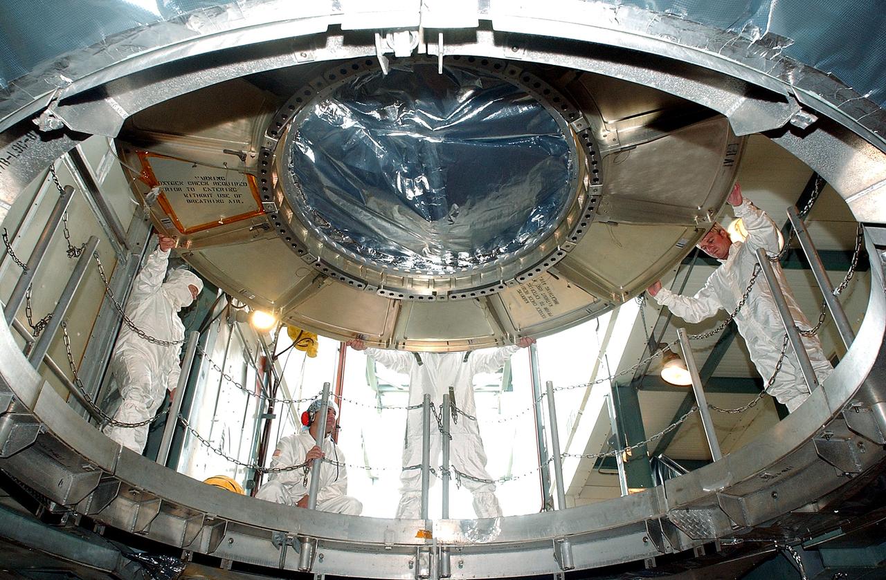 KENNEDY SPACE CENTER, FLA.  -  The Space Infrared Telescope Facility (SIRTF) is lowered into the opening of the mobile service tower on Launch Pad 17-B, Cape Canaveral Air Force Station.  SIRTF will be attached to the Delta II rocket and encapsulated in its fairing before launch.   Consisting of three cryogenically cooled science instruments and an 0.85-meter telescope, SIRTF is one of NASA’s largest infrared telescopes to be launched.  It is the fourth and final element in NASA’s family of orbiting “Great Observatories.”  SIRTF will obtain images and spectra by detecting the infrared energy, or heat, radiated by objects in space. Most of this infrared radiation is blocked by the Earth's atmosphere and cannot be observed from the ground.